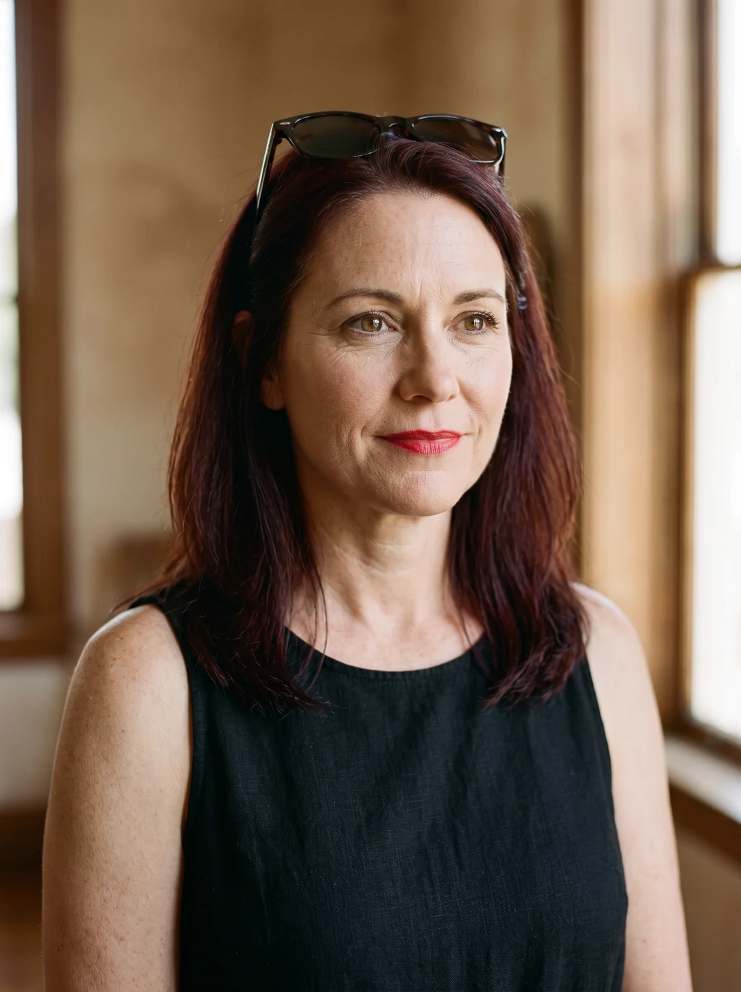 Fictional screen portrayal of Samantha Lake, with auburn hair, sunglasses, and a black sundress